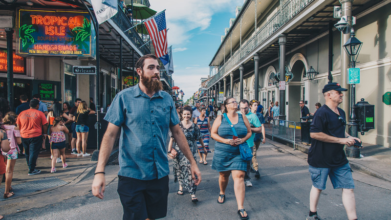 Travellers walk down Bourbon Street