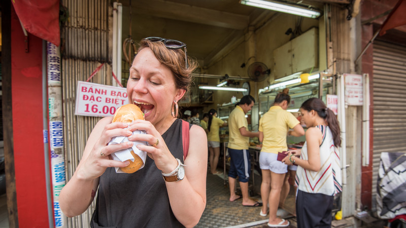 Woman eating a banh mi in Vietnam