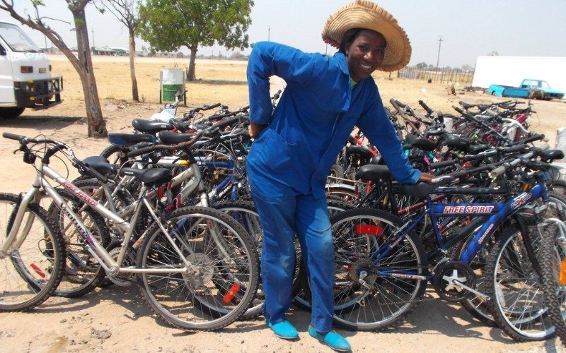 A female mechanic stnads in front of hundreds of bikes