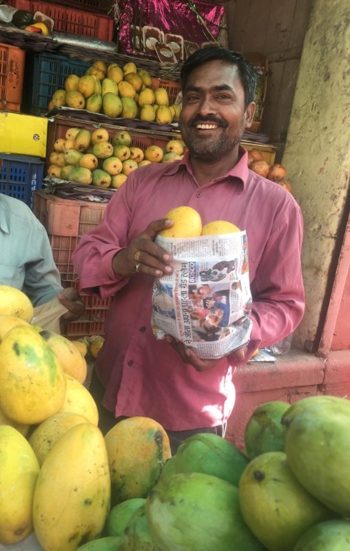 Indian man holding bag of mangoes