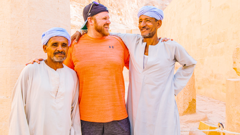 a traveller standing with two local men in Egypt