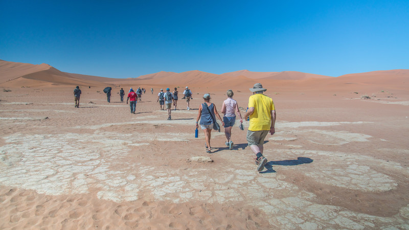 Travellers walking across the salt pans in Namibia