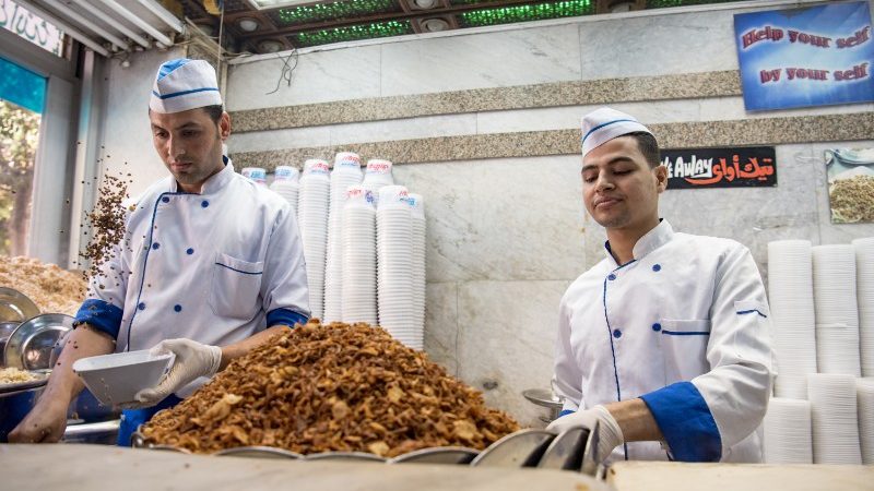 Two men making koshari in Egypt