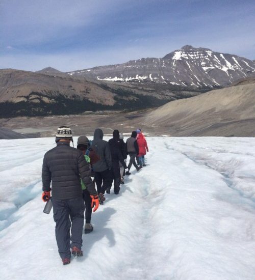 Travellers hike across a glacier in Canada