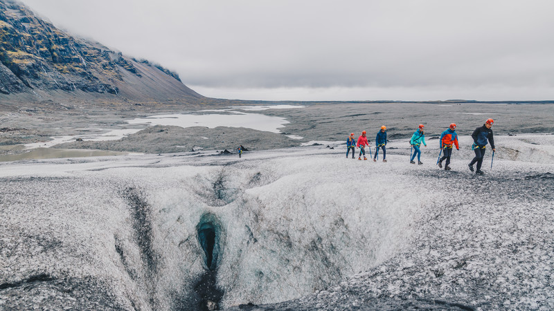 A group of 6 travellers traverse one of Iceland's glaciers.
