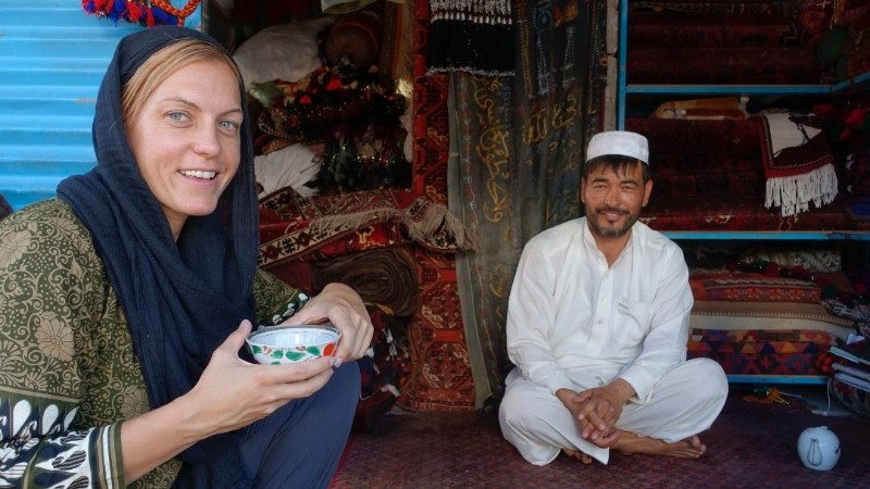 A young woman drinking tea with an Afghani man