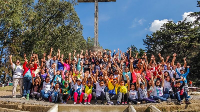 A big group of students with their hands in the air