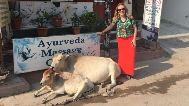 Woman poses with two cows in India