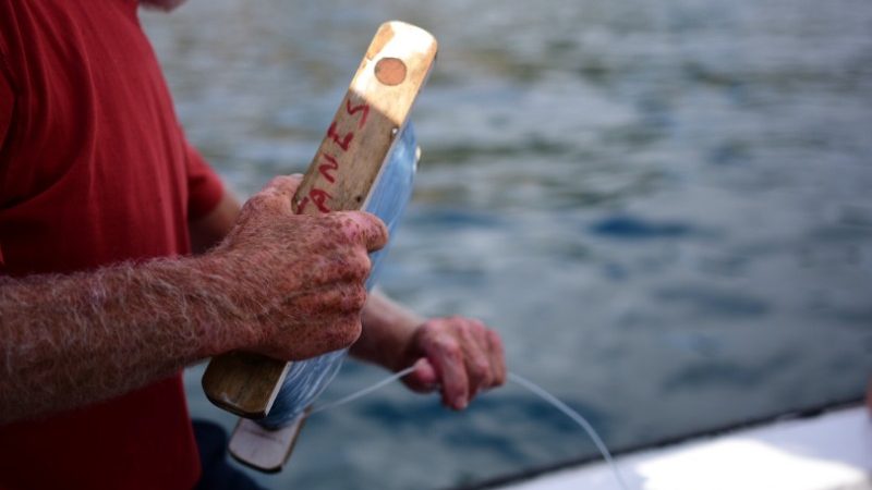 A man holding a fishing line on a boat