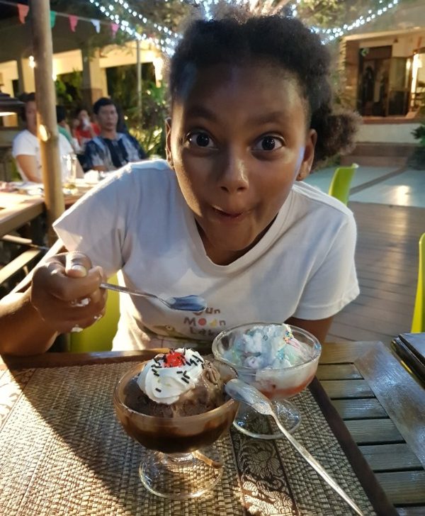 A girl excitedly eating ice cream in Thailand