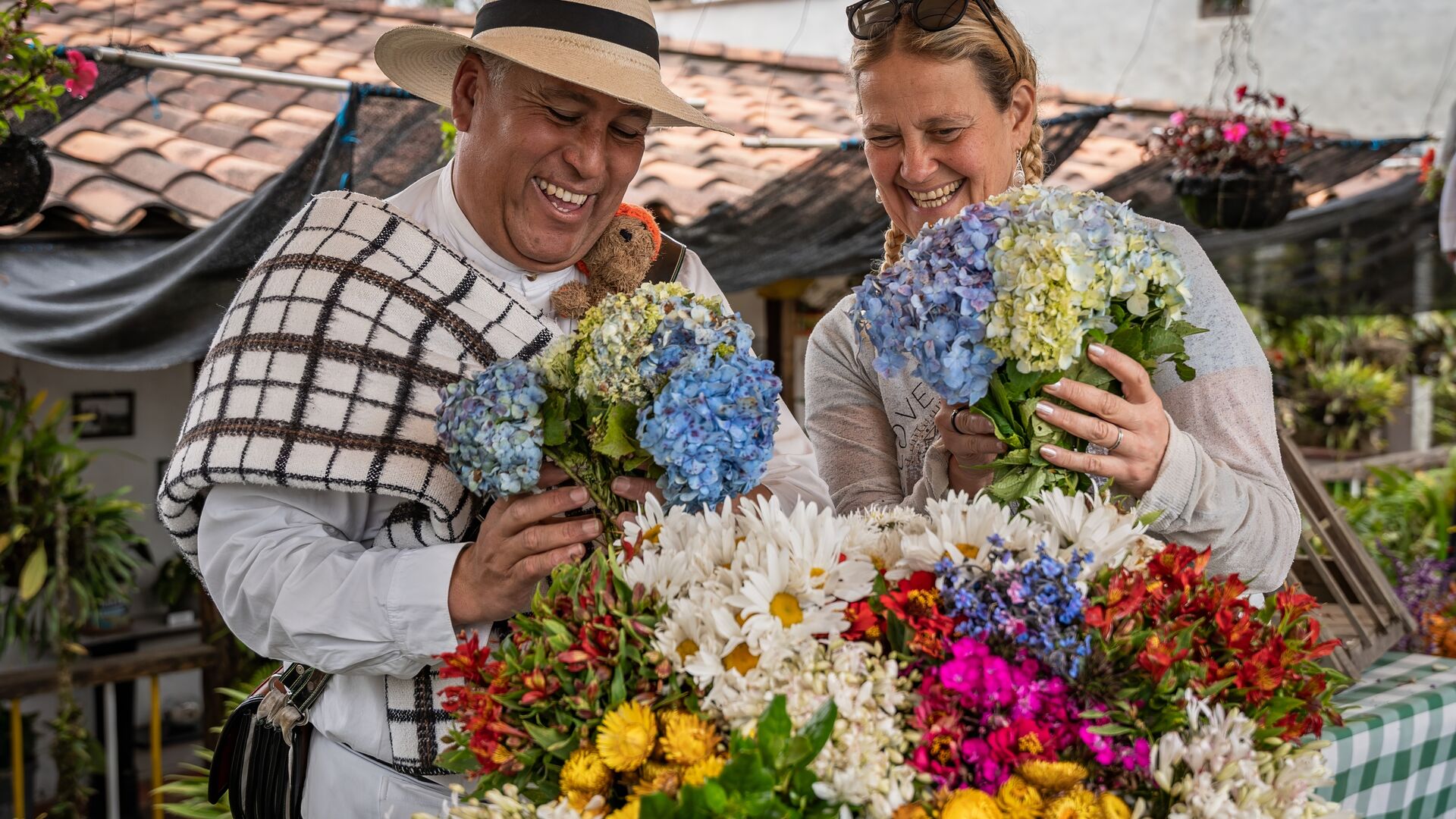 A traveller and local holding flowers and smiling in Colombia.
