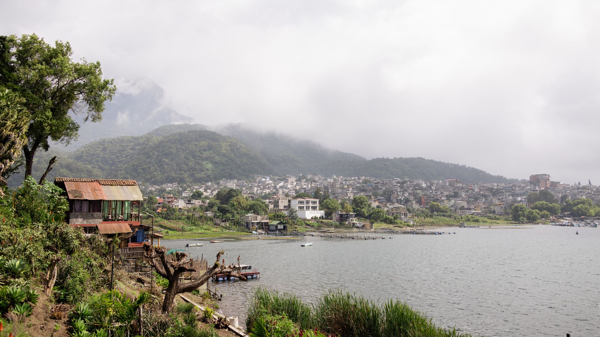 Atitlan Lake in Guatemala with a mountain in the background and a city along the shore.
