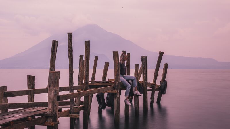 Girl sitting on the dock at Lake Atitlan, Guatemala