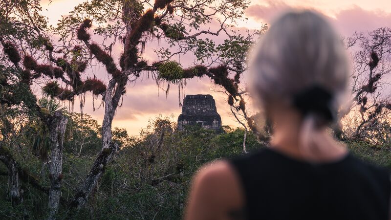 A girl looks at a monument in Tikal, Guatemala