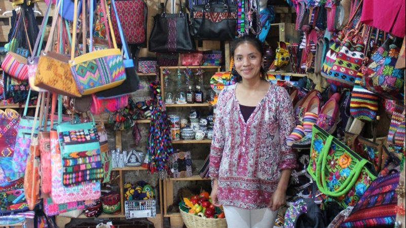 A woman stands in her shop full of handcrafted goods