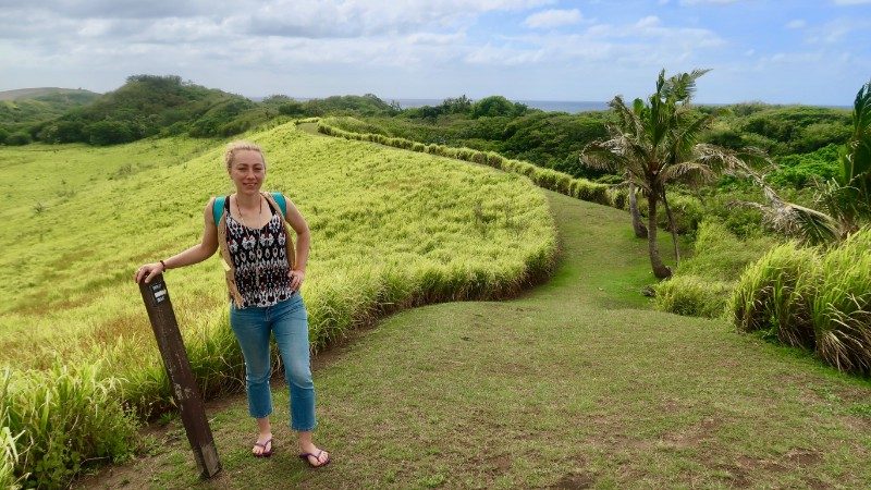 Woman hiking through green fields in Fiji