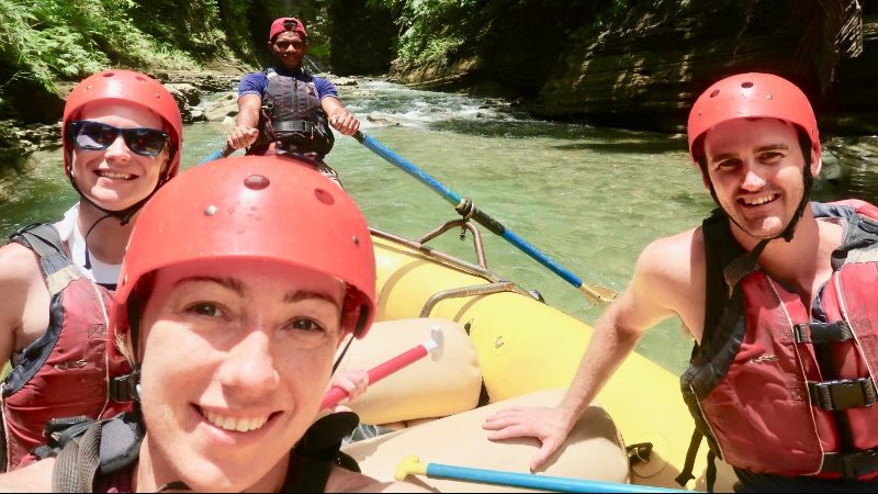 People wearing red helmets while rafting