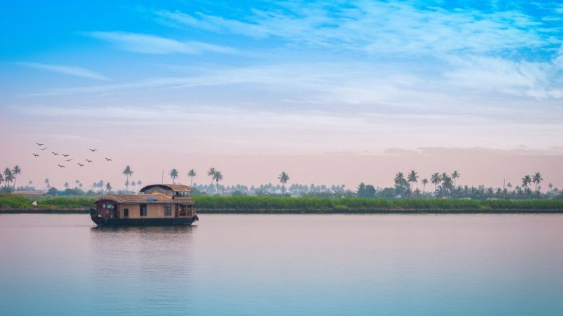 A houseboat on a tranquil river at dusk