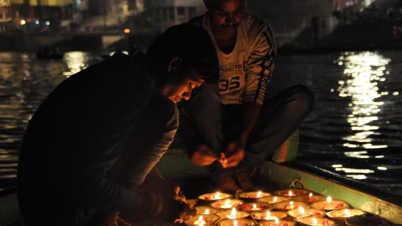 Two men lighting candles in Varanasi