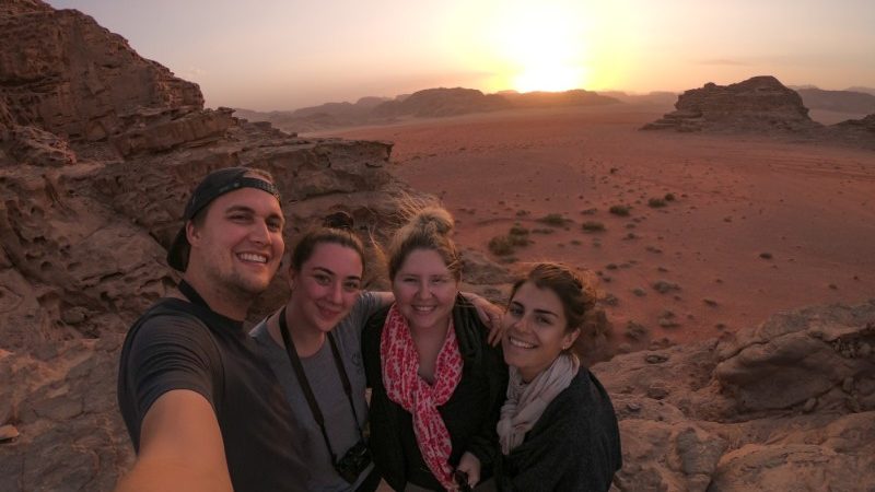 Four travellers taking a selfie in the desert.