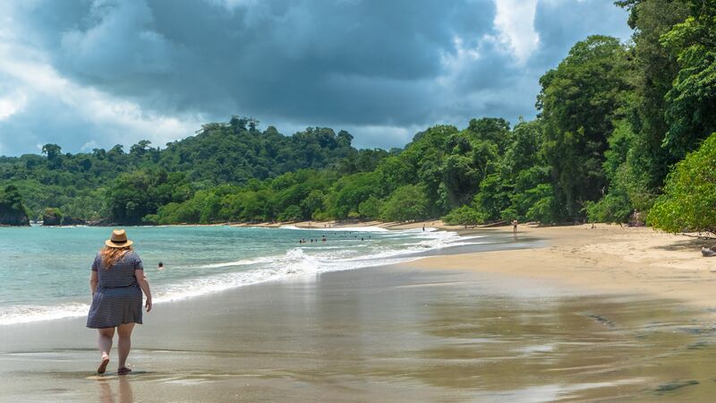 A traveller walks along the beach