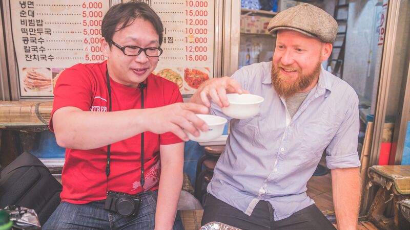 Two men enjoying soup in South Korea