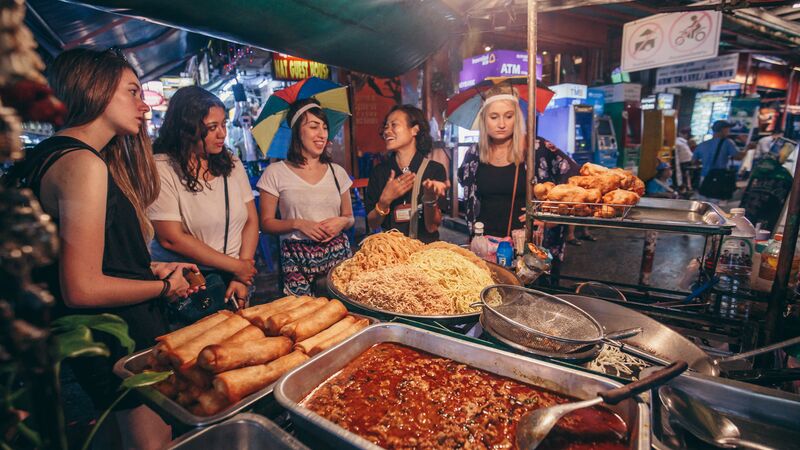 Travellers at a street food stall in Thailand