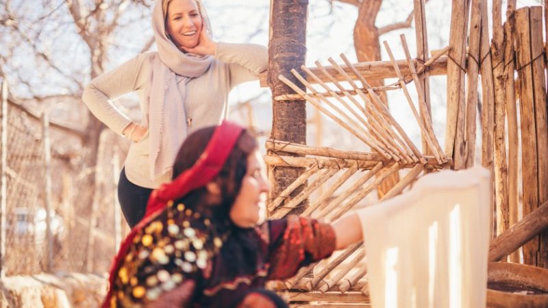 A traveller watches as a local Iranian woman makes bread