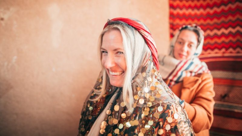 A traveller gets dressed in traditional clothing for a party