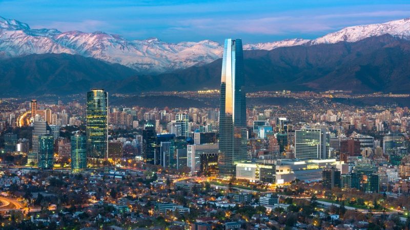 View of a busy city with snow-capped mountains in the background