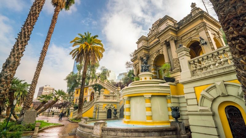 An old building surrounded by palm trees in Santiago