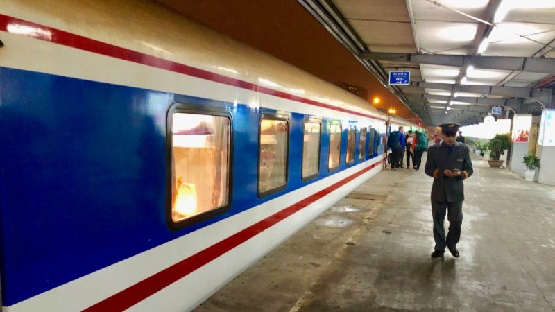 A train in Vietnam with a station attendant