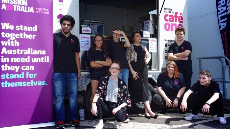 Students sitting in front of a coffee trailer