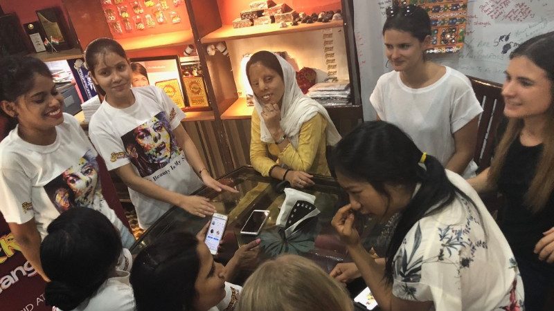 A group of women stand around a table