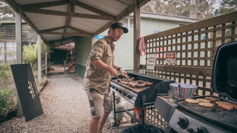 A man barbecuing sausages