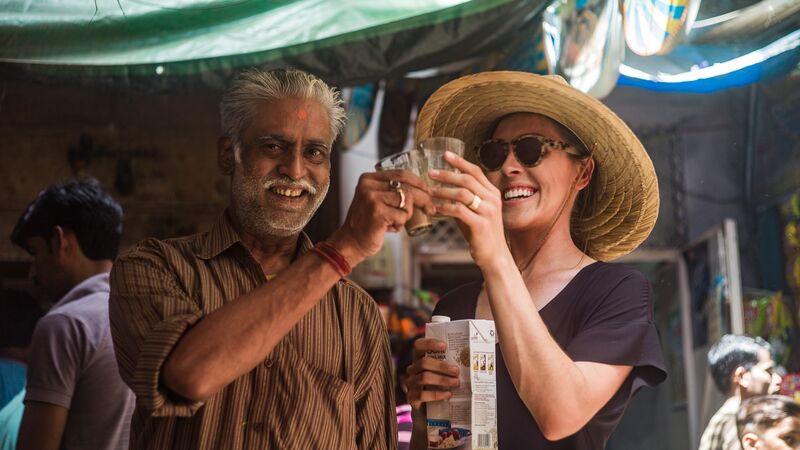Two people sharing a cup of chai tea in India
