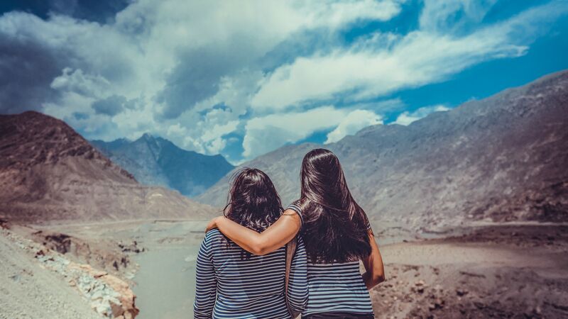 Two women in Pakistan looking over some mountains