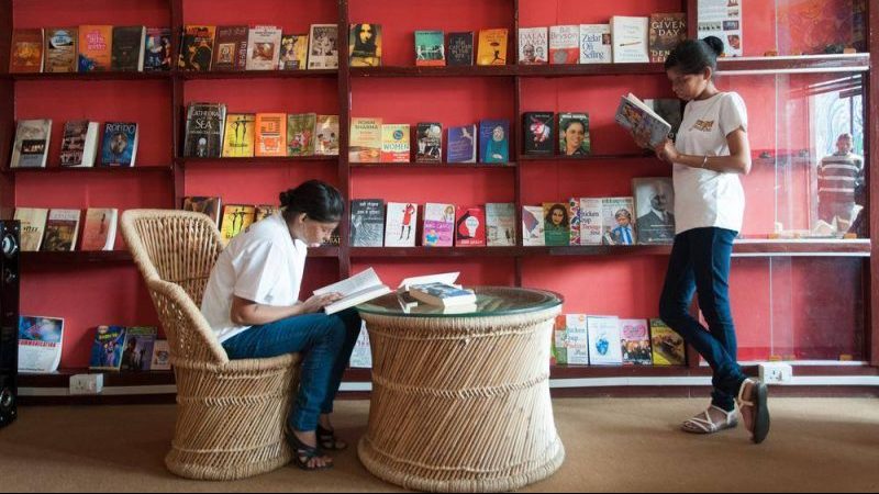 Two women reading in a bookshop in India