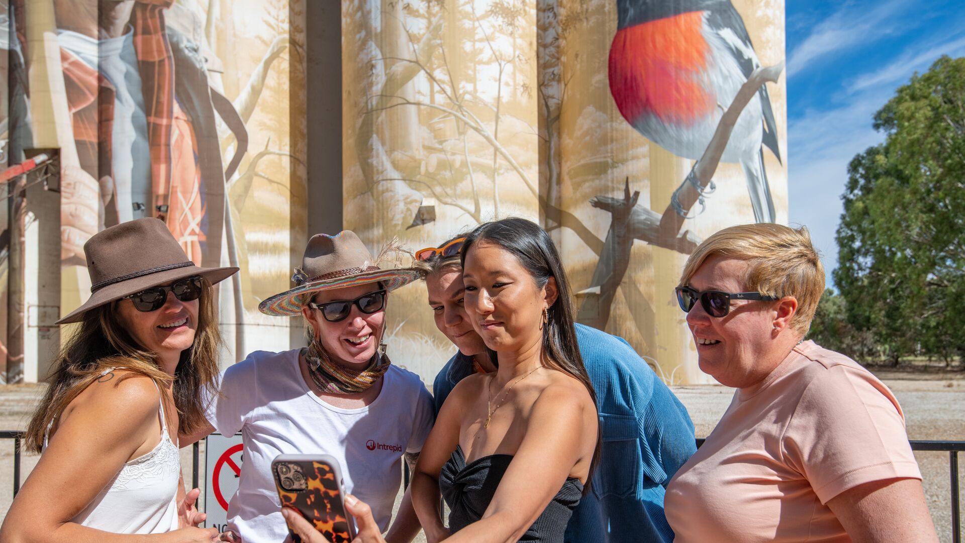 An Intrepid leader poses for a selfie with travellers by South Australia Wirrabarra Silo Art.