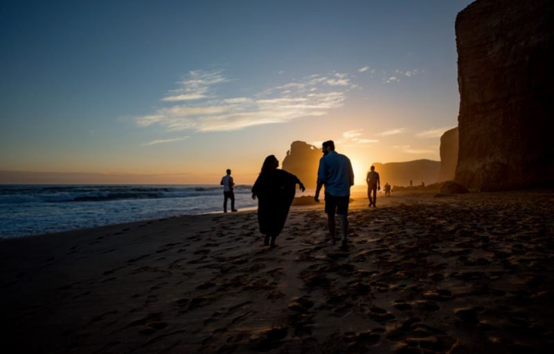 Travellers walking along the beach