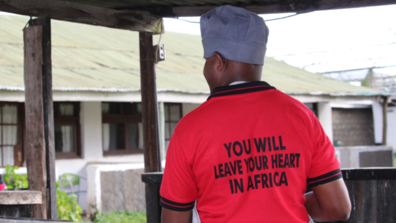 a man wearing a shirt that says "you will leave your heart in Africa" on a Kenya safari