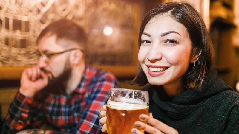 A woman drinking beer in a pub