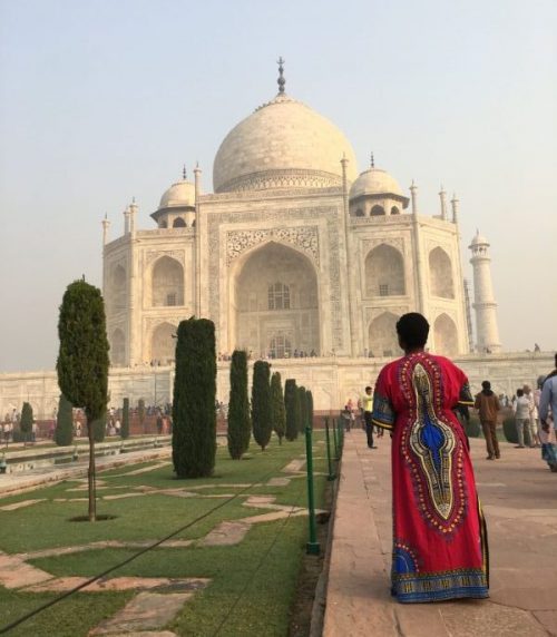 A woman standing in front of the Taj Mahal