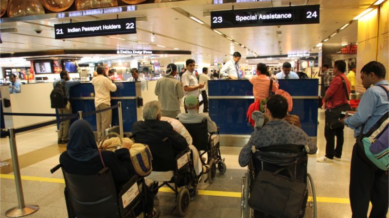 A line of people in wheelchairs waiting at the airport.