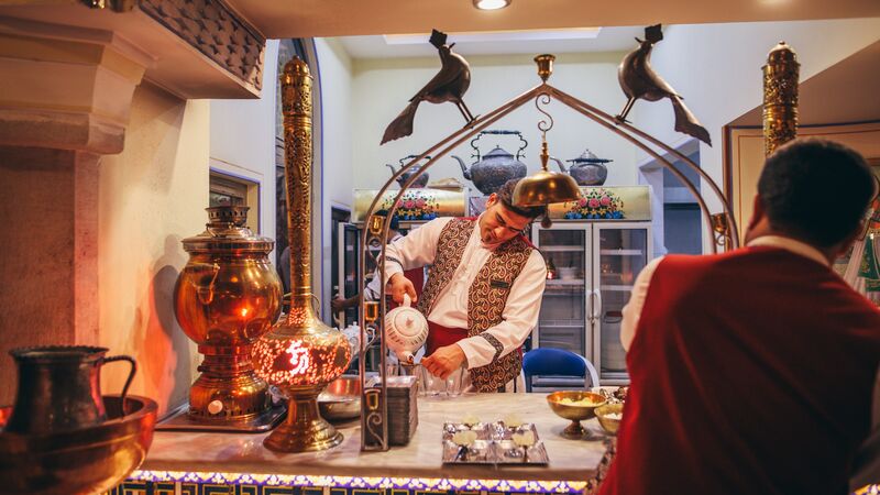 A man pours tea in a market