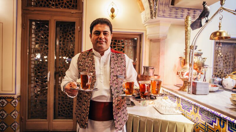 A man holding a tray of tea in Iran