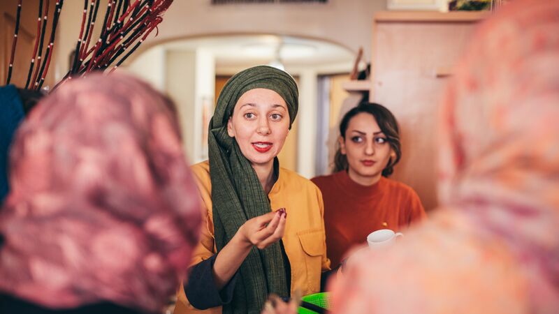 Young woman wearing a headscarf with a group of travellers