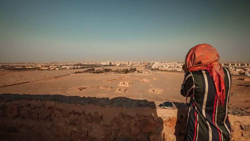 A woman wearing a headscarf looks at the view in iran