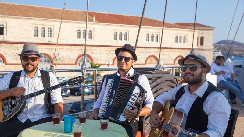 Three musicians playing aboard a boat.