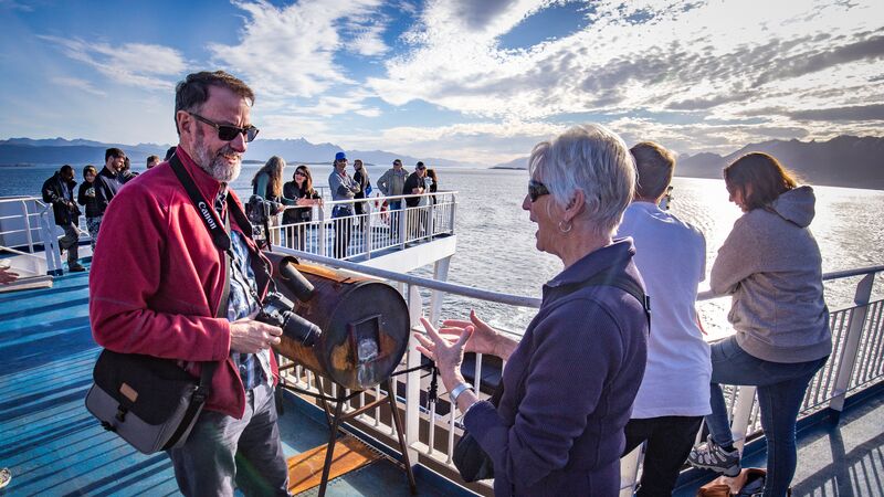 Two older travellers talk onboard the deck of the Ocean Endeavour